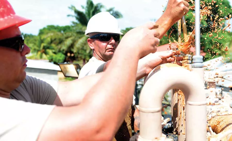Drillers fix desander cones on a fluid tank