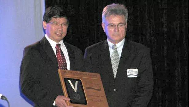 Chunmiao Zheng, left, accepts the group's top science award from NGWA President Daniel T. Meyer.