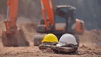 OSHA's Construction Safety Two hard hats placed on the ground at a construction site