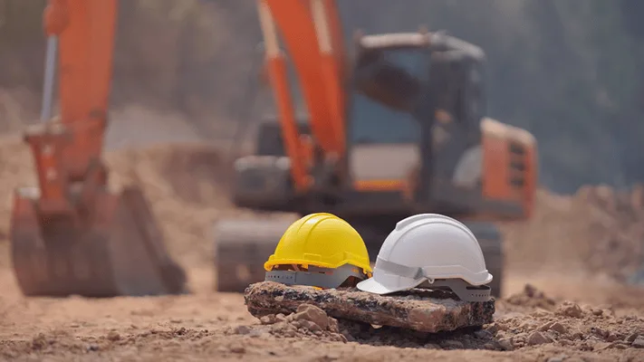 OSHA's Construction Safety Two hard hats placed on the ground at a construction site