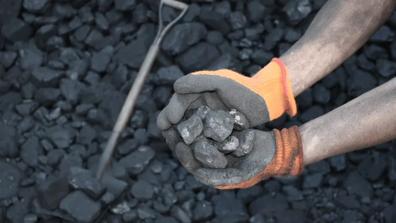 An image of a worker holding coal.