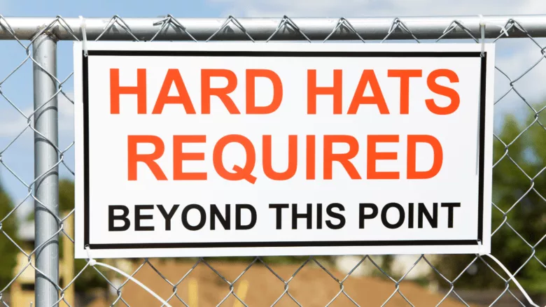 A sign saying that hard harts are required beyond this area.