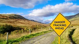 An image of a fracking sign in the countryside