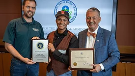 The student posing with his award from the EPA