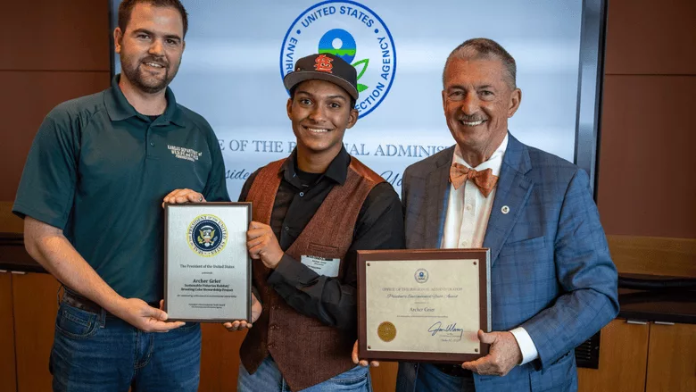 The student posing with his award from the EPA