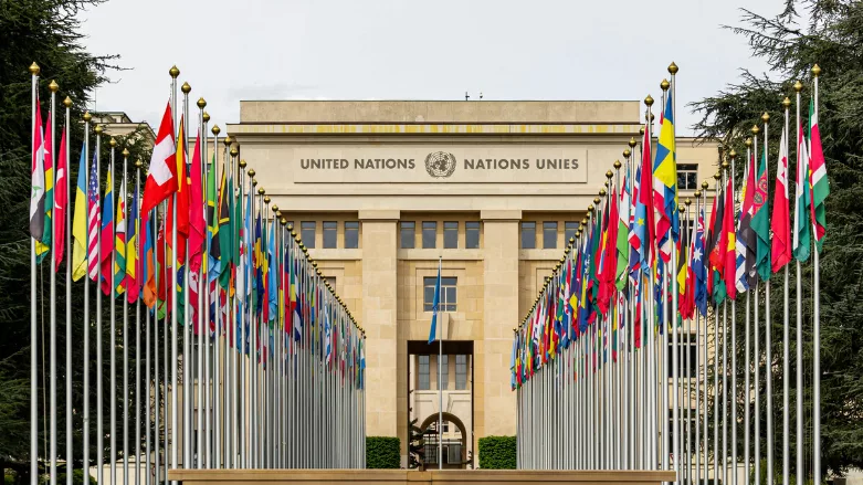 An image of the U.N. building with flags around it.