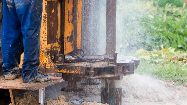 An image of a well being drilled and water spouting