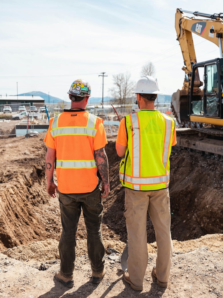 Construction workers looking at a hole