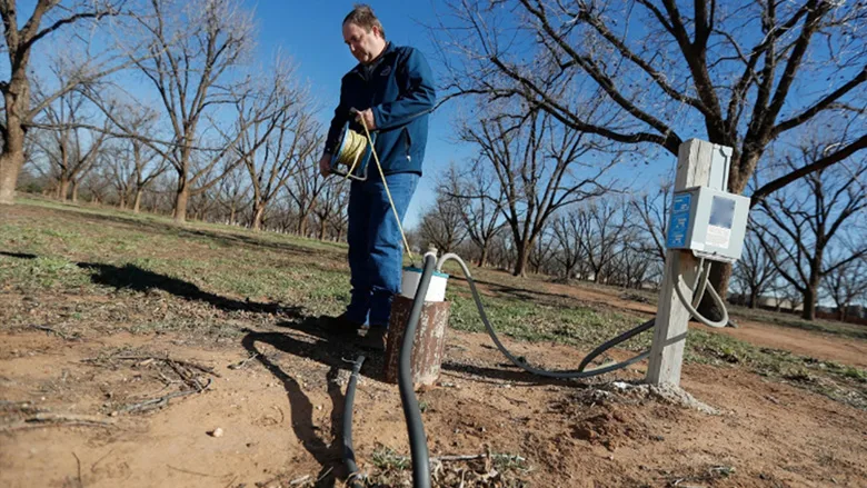 A man checking the water level at the Ogalla Aquifer