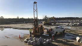 A drilling rig hitched to a pickup truck