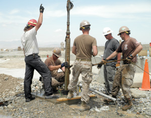 Deployed Seebees work to repair a submersible well pump