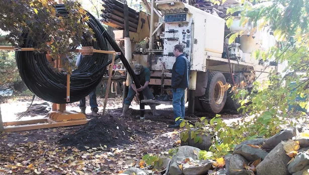 Drillers with Colaluce Well & Pump Service feed Twister piping from a reel into a borehole at a jobsite in New Jersey.