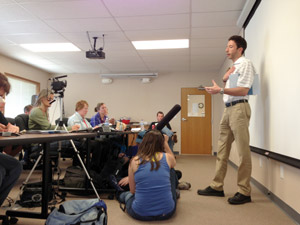 Jason Manshum fields questions from a room full of reporters