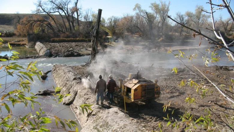 drill crew prepares a hole for explosives
